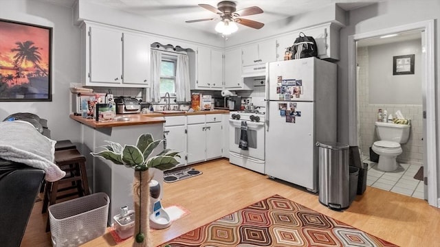160-162 Rockland St, Fall River, MA 02724 - kitchen with white appliances, a sink, a ceiling fan, light wood-style floors, and white cabinetry