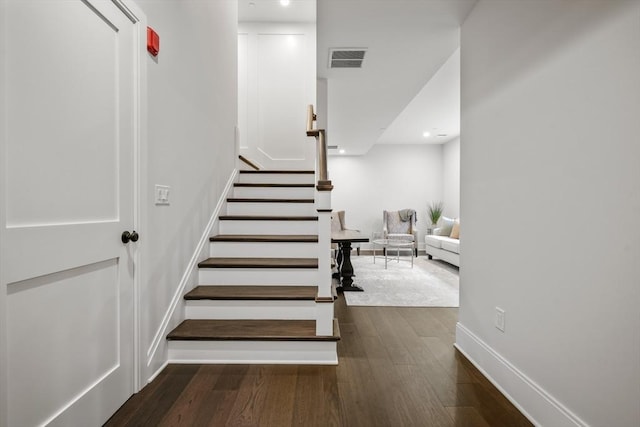 staircase with baseboards, recessed lighting, wood finished floors, and visible vents