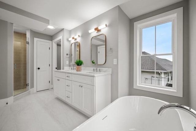 full bath featuring double vanity, a freestanding tub, a shower stall, a sink, and baseboards