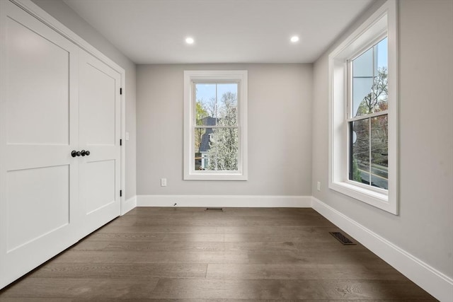 interior space featuring recessed lighting, baseboards, visible vents, and dark wood finished floors