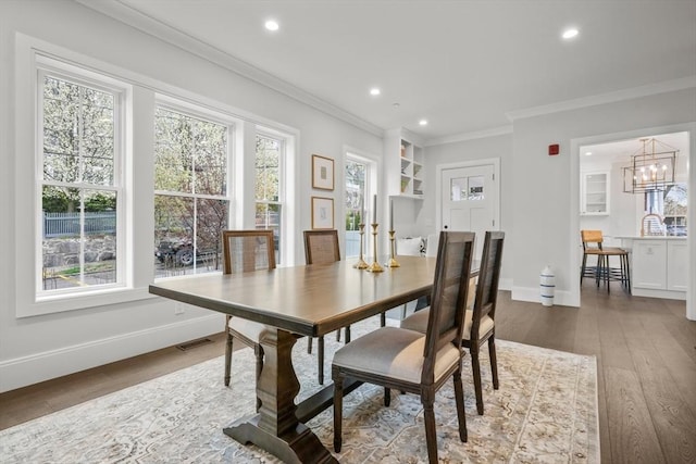 dining room with recessed lighting, ornamental molding, and wood finished floors