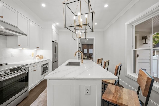 kitchen featuring a sink, an island with sink, ornamental molding, and stainless steel appliances