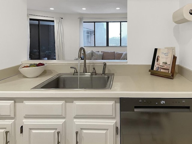 kitchen with white cabinetry, sink, and black dishwasher