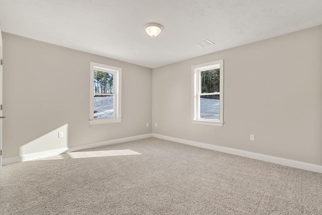 carpeted empty room with a healthy amount of sunlight