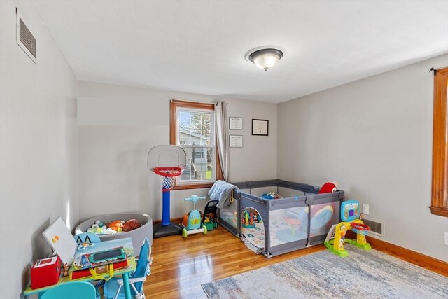 bedroom featuring baseboards, visible vents, and wood finished floors