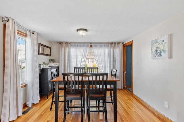 dining room with visible vents, light wood-type flooring, and baseboards