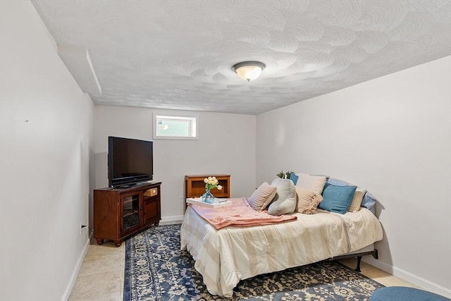 bedroom with a textured ceiling and baseboards