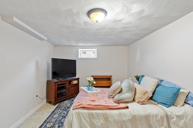 bedroom with baseboards and a textured ceiling