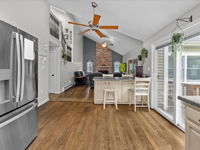 235 Stone School Rd, Sutton, MA 01590 - kitchen featuring stainless steel fridge, a ceiling fan, a large fireplace, baseboard heating, and dark wood-style flooring