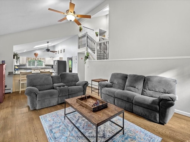 235 Stone School Rd, Sutton, MA 01590 - living area with ceiling fan, a baseboard radiator, stairway, wood finished floors, and high vaulted ceiling