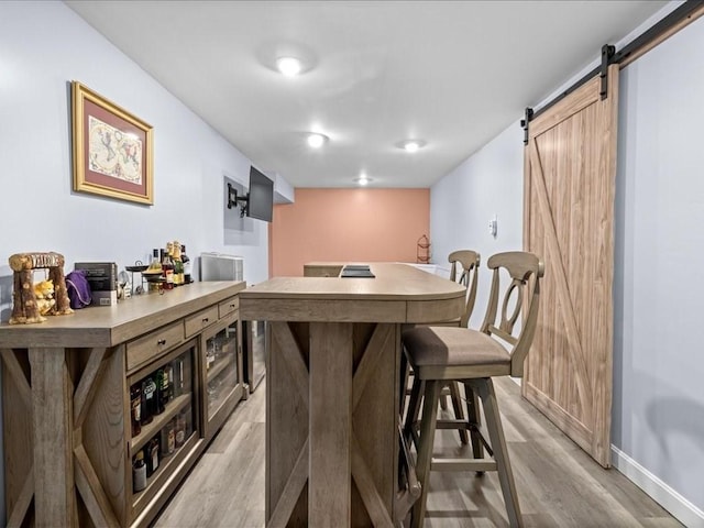 235 Stone School Rd, Sutton, MA 01590 - dining room with a barn door, light wood-style flooring, and baseboards