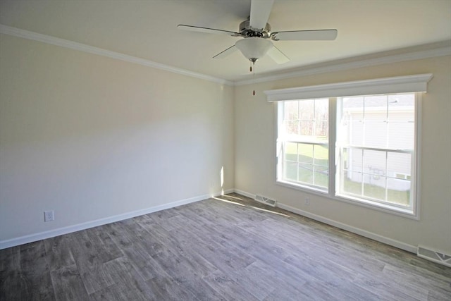 spare room with crown molding, dark wood-type flooring, and ceiling fan