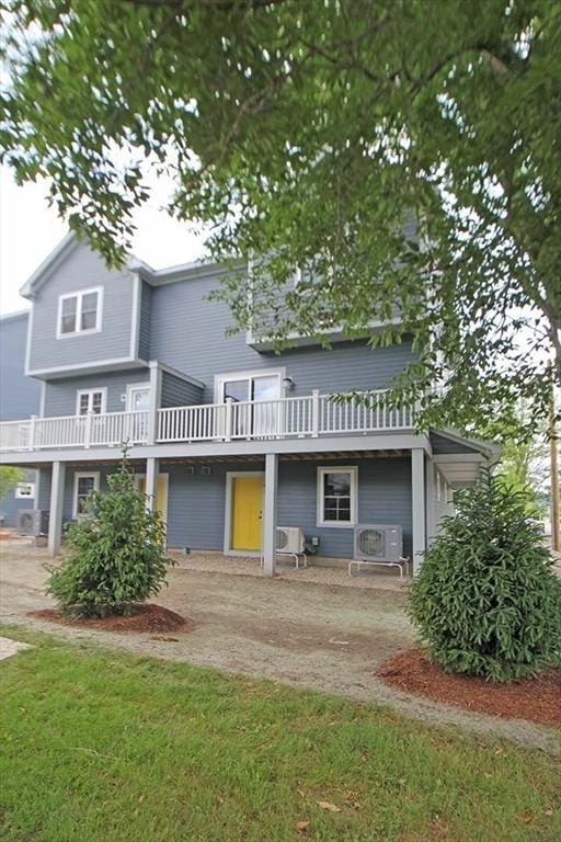 view of front of property featuring a wooden deck, ac unit, and a front lawn