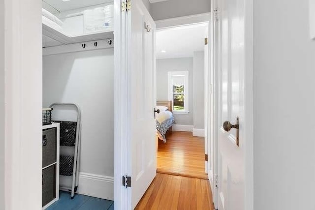 corridor with baseboards and wood finished floors