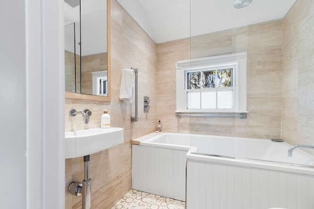 bathroom featuring tile walls and a bath