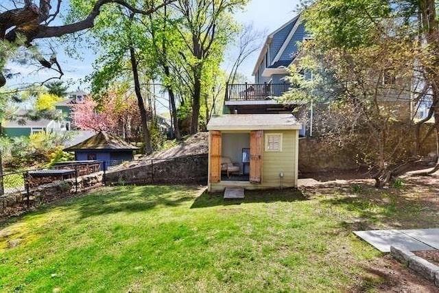 back of property with an outdoor structure, a fenced backyard, a shed, and a yard