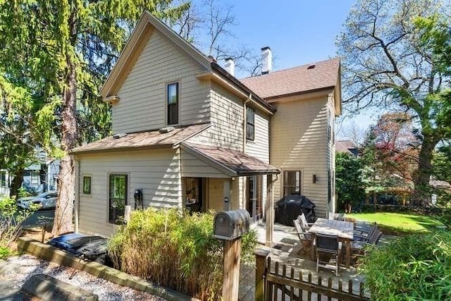 rear view of house with a chimney and a patio area