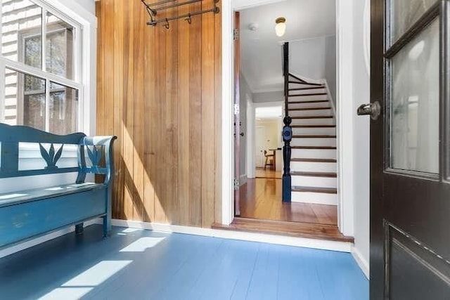 interior space featuring wooden walls, baseboards, and wood finished floors