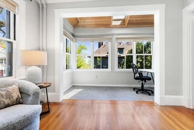 doorway with plenty of natural light, baseboards, and wood finished floors