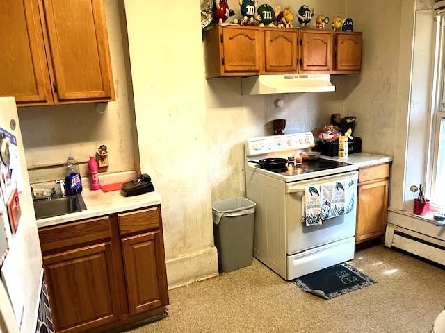40 Byers St, Springfield, MA 01105 - kitchen with white appliances, under cabinet range hood, light countertops, and brown cabinetry