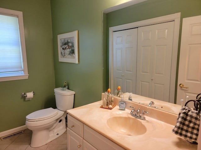 bathroom with a wealth of natural light, vanity, toilet, and tile patterned flooring