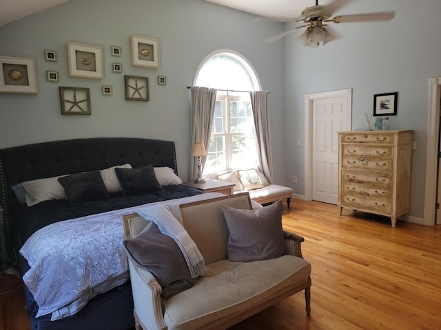 bedroom with light wood-type flooring, vaulted ceiling, and ceiling fan