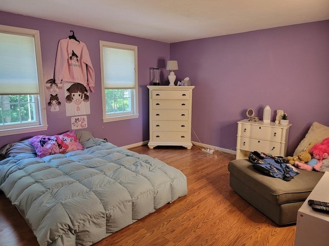 bedroom with multiple windows and light wood-type flooring