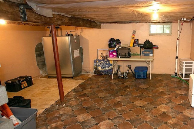 below grade area with freestanding refrigerator and tile patterned floors