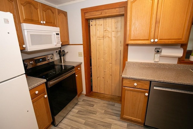 kitchen with appliances with stainless steel finishes, crown molding, light wood-style flooring, and brown cabinets