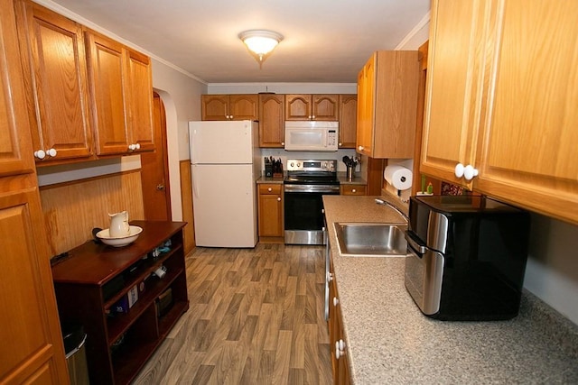 kitchen featuring white appliances, a sink, arched walkways, brown cabinetry, and crown molding