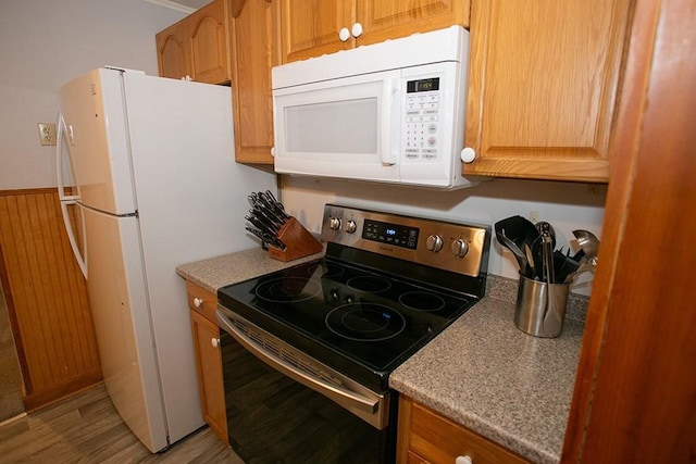 kitchen with white appliances and light wood-style flooring