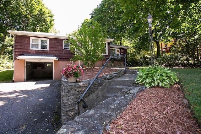view of front of property with driveway, a garage, and stairs
