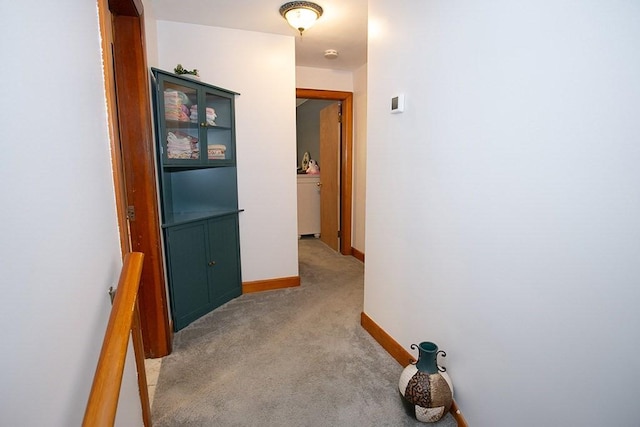 hall featuring light carpet and baseboards