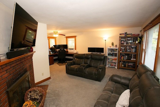 carpeted living area with a desk, a fireplace, and ceiling fan