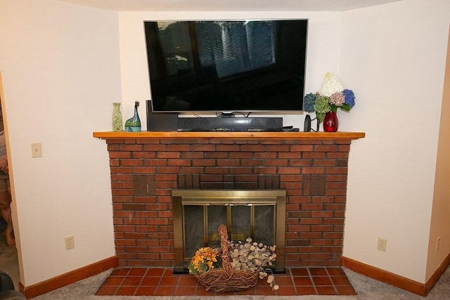 detailed view of baseboards, a brick fireplace, and carpet floors