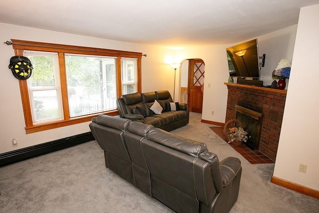 living area with carpet floors, a brick fireplace, arched walkways, and baseboards