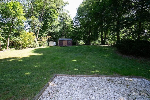 view of grassy yard with a storage unit and an outdoor structure