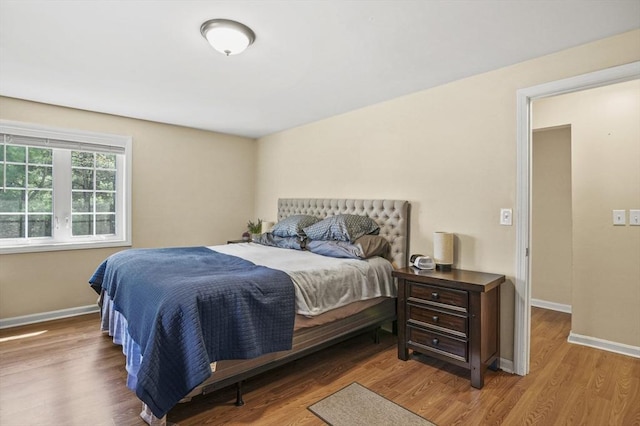 bedroom featuring wood finished floors and baseboards