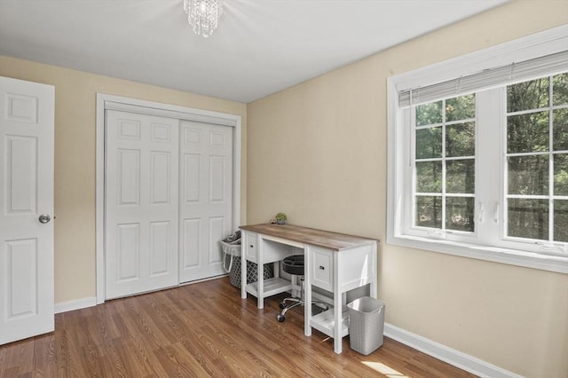 home office with baseboards, wood finished floors, and an inviting chandelier