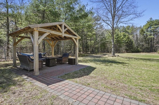 view of yard featuring a patio, a gazebo, a fire pit, and a forest view