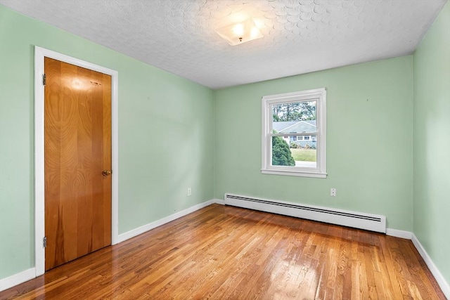 18 Fairview Rd, Westborough, MA 01581 - spare room with a baseboard heating unit, hardwood / wood-style flooring, and a textured ceiling