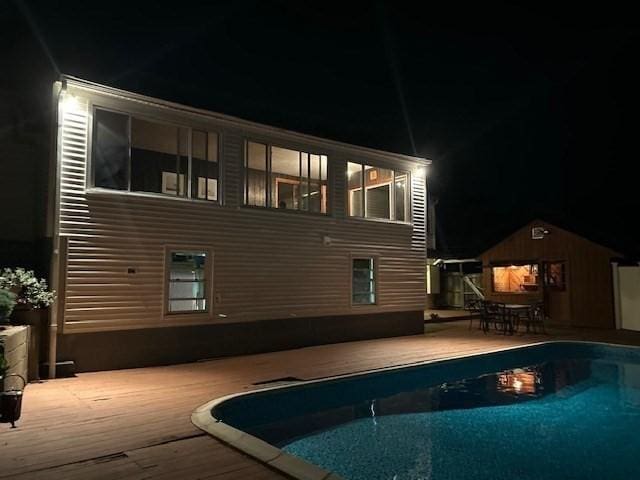 18 Fairview Rd, Westborough, MA 01581 - back of house at twilight with an outdoor pool, an outdoor structure, and a wooden deck