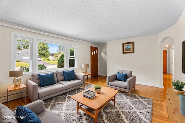 18 Fairview Rd, Westborough, MA 01581 - living area with arched walkways, a textured ceiling, and light wood-style floors