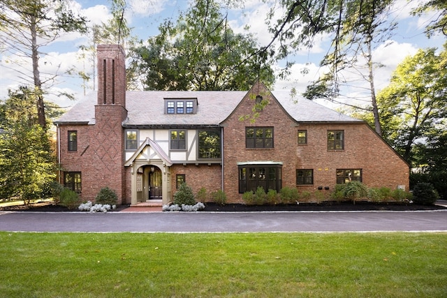 tudor house featuring a front lawn