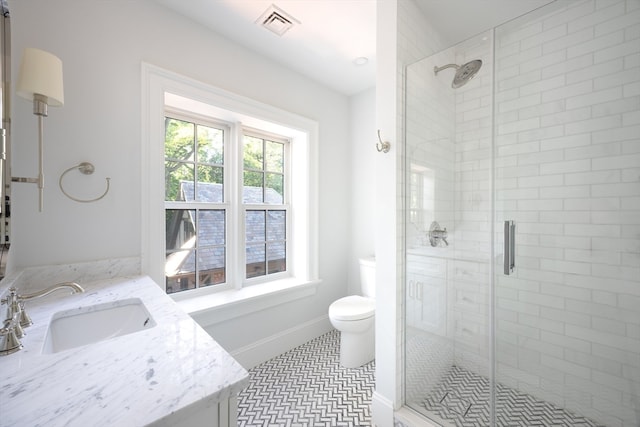 bathroom featuring vanity, toilet, tile patterned floors, and an enclosed shower