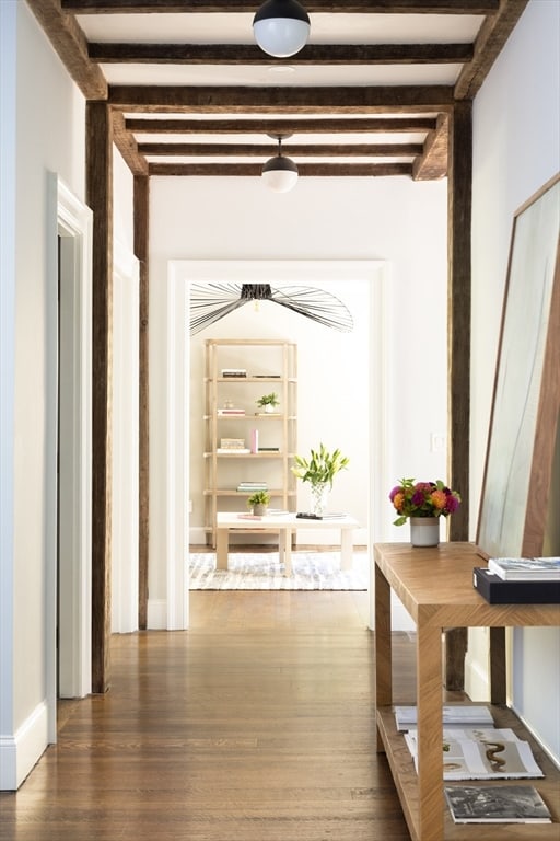 hallway featuring beam ceiling and dark hardwood / wood-style floors