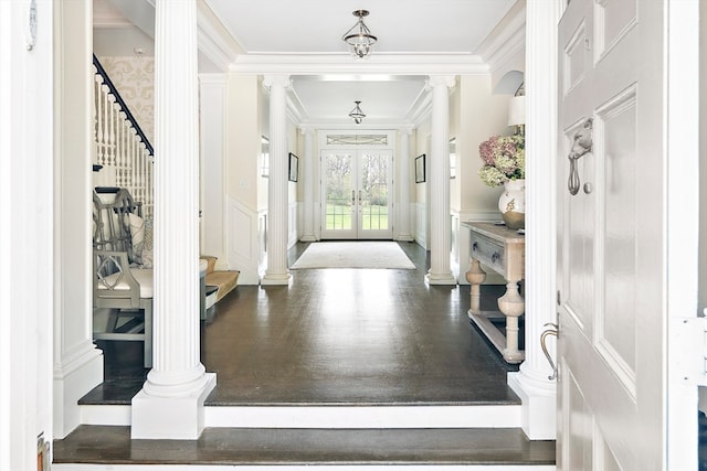 foyer featuring ornamental molding, french doors, hardwood / wood-style flooring, and decorative columns