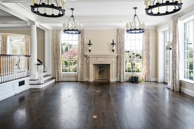 unfurnished living room with a healthy amount of sunlight, ornamental molding, dark hardwood / wood-style floors, and decorative columns