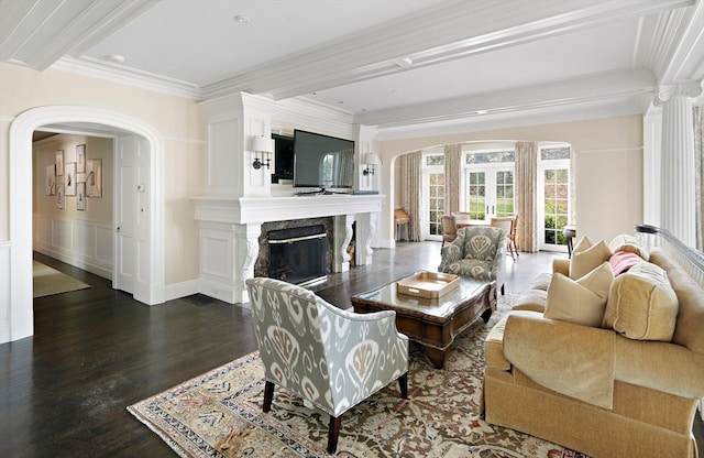 living room with crown molding, a fireplace, and dark wood-type flooring