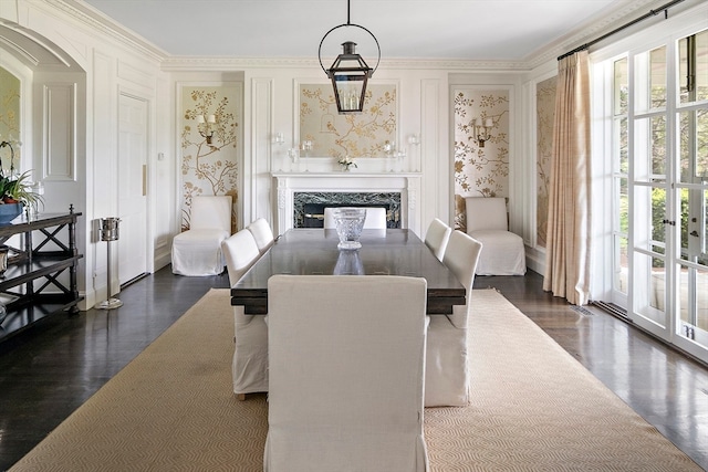 dining area with a high end fireplace, ornamental molding, and dark wood-type flooring